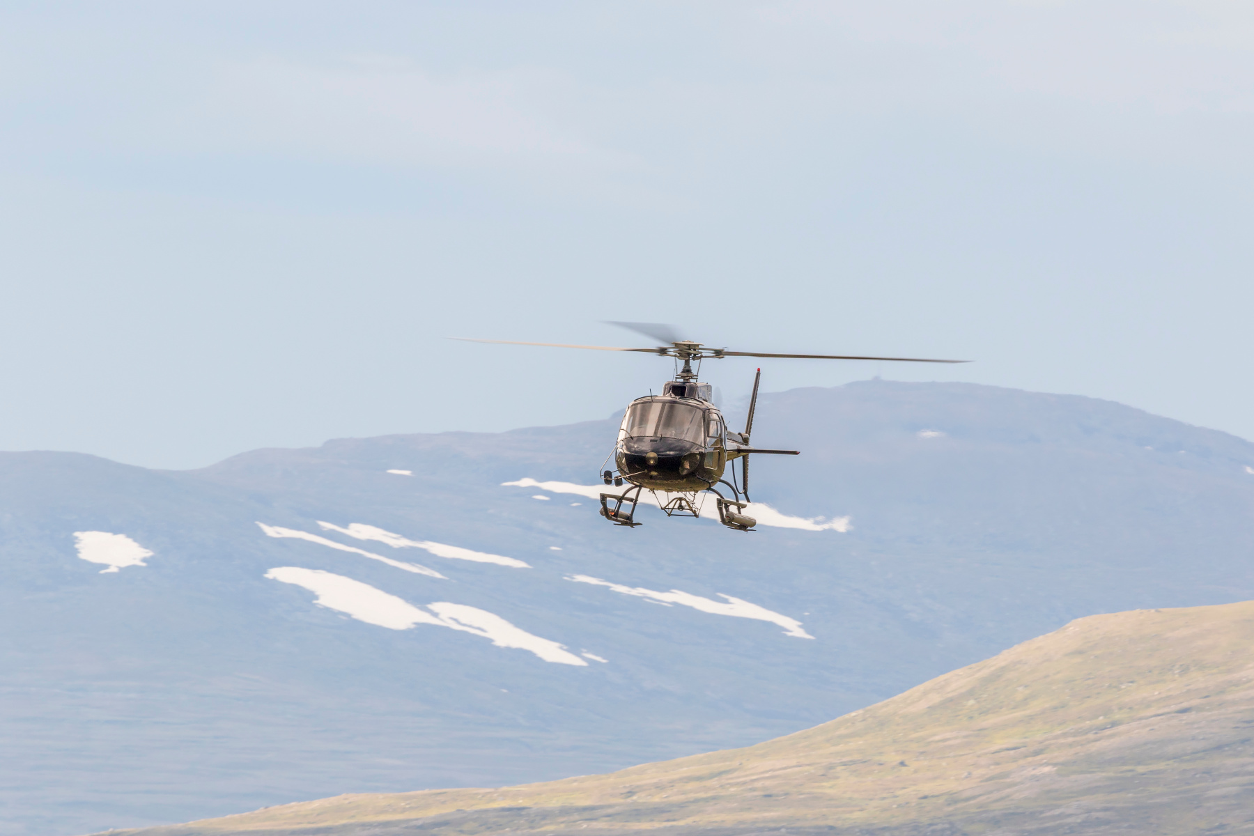 Helikopter flyvende i fjellandskap