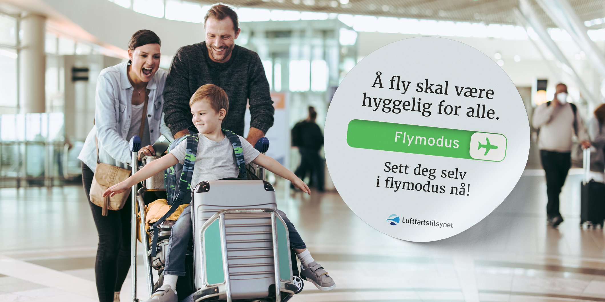 En lykkelig familie deler et øyeblikk av glede på flyplassen, mens sønnen deres, sittende på bagasjen, smiler bredt. Bakgrunnen viser en kampanje fra Luftfartstilsynet som oppmuntrer til å sette elektroniske enheter i flymodus for en behagelig flyopplevelse for alle.